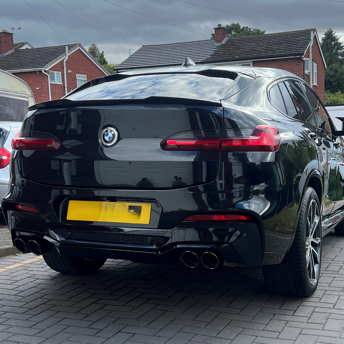 Gloss black rear diffuser with exhaust tips for BMW G02 X4, featuring a sleek, aerodynamic design and high-quality finish.