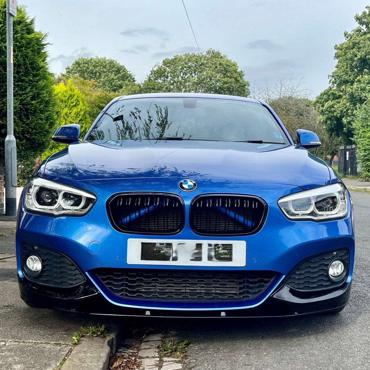 Gloss black front splitter for BMW F20 F21 1 Series LCI 2015-2019, made of durable material, enhances sporty appearance.
