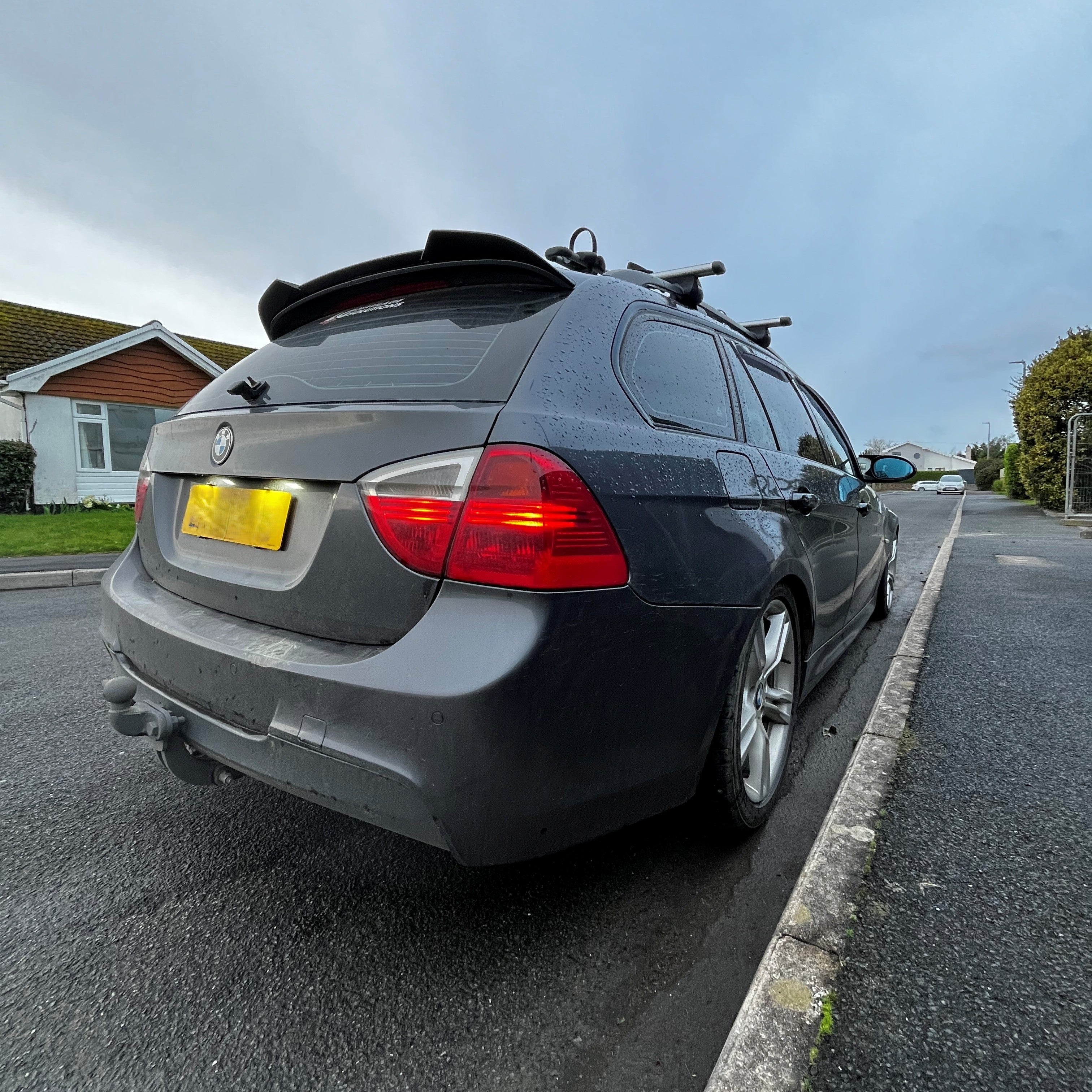 Car parked on the side of a road with a clear sky background