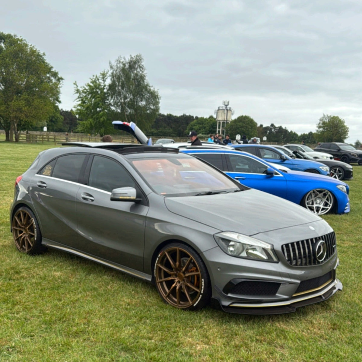 Gloss Black front splitter for Mercedes Benz W176 A Class 2013-2015, showing the sleek, aerodynamic design and fitment details.