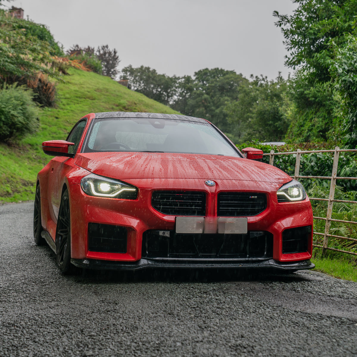 Gloss black front splitter for BMW G87 M2 23-present, designed to enhance aerodynamics and sporty appearance.