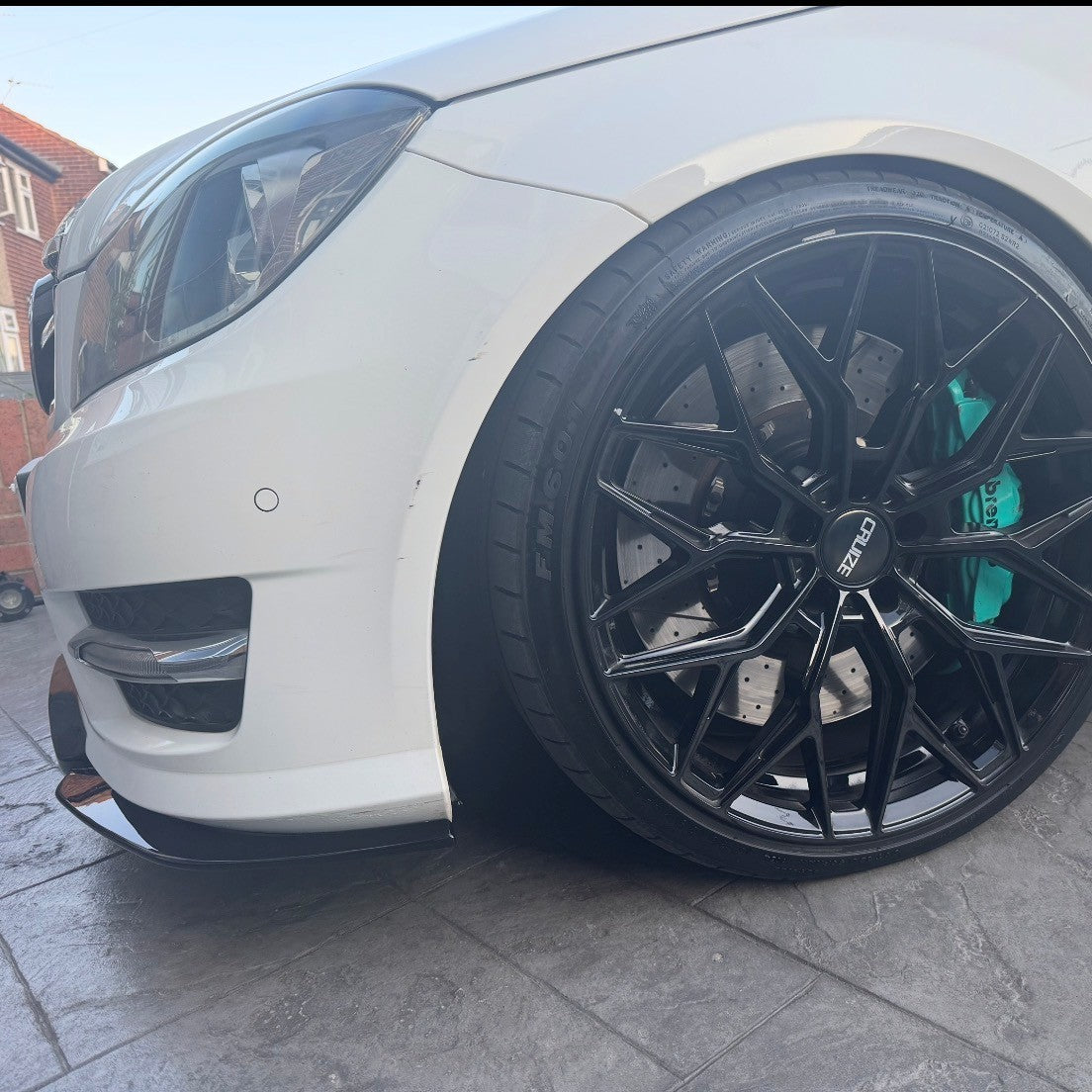 Gloss Black front splitter for Mercedes Benz W204 C-Class 2008-2014, enhancing sporty appearance with aerodynamic styling.