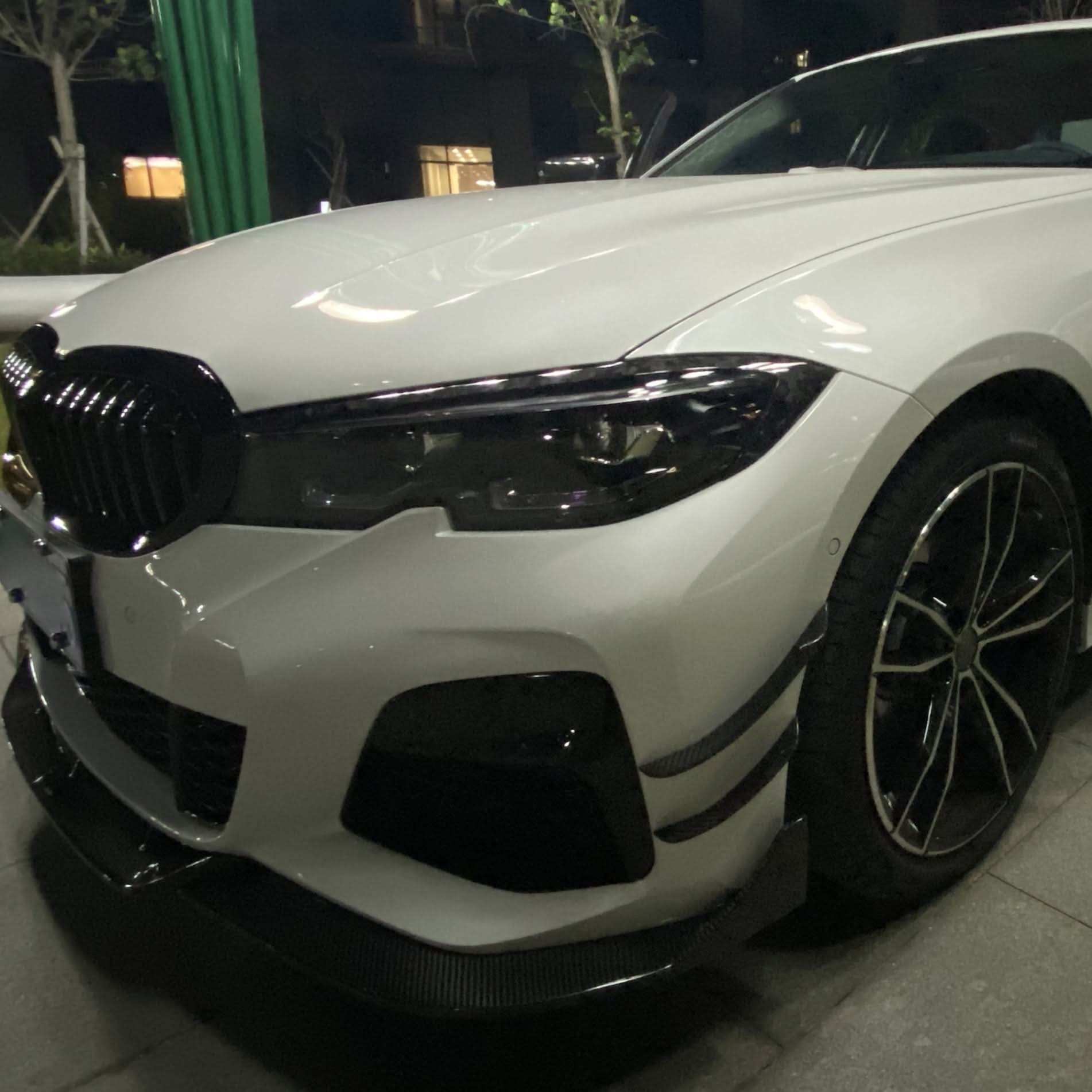 Carbon fibre front headlight trims for BMW G20 G21 3 Series M Sport, stylish accessory enhancing vehicle’s front appearance.