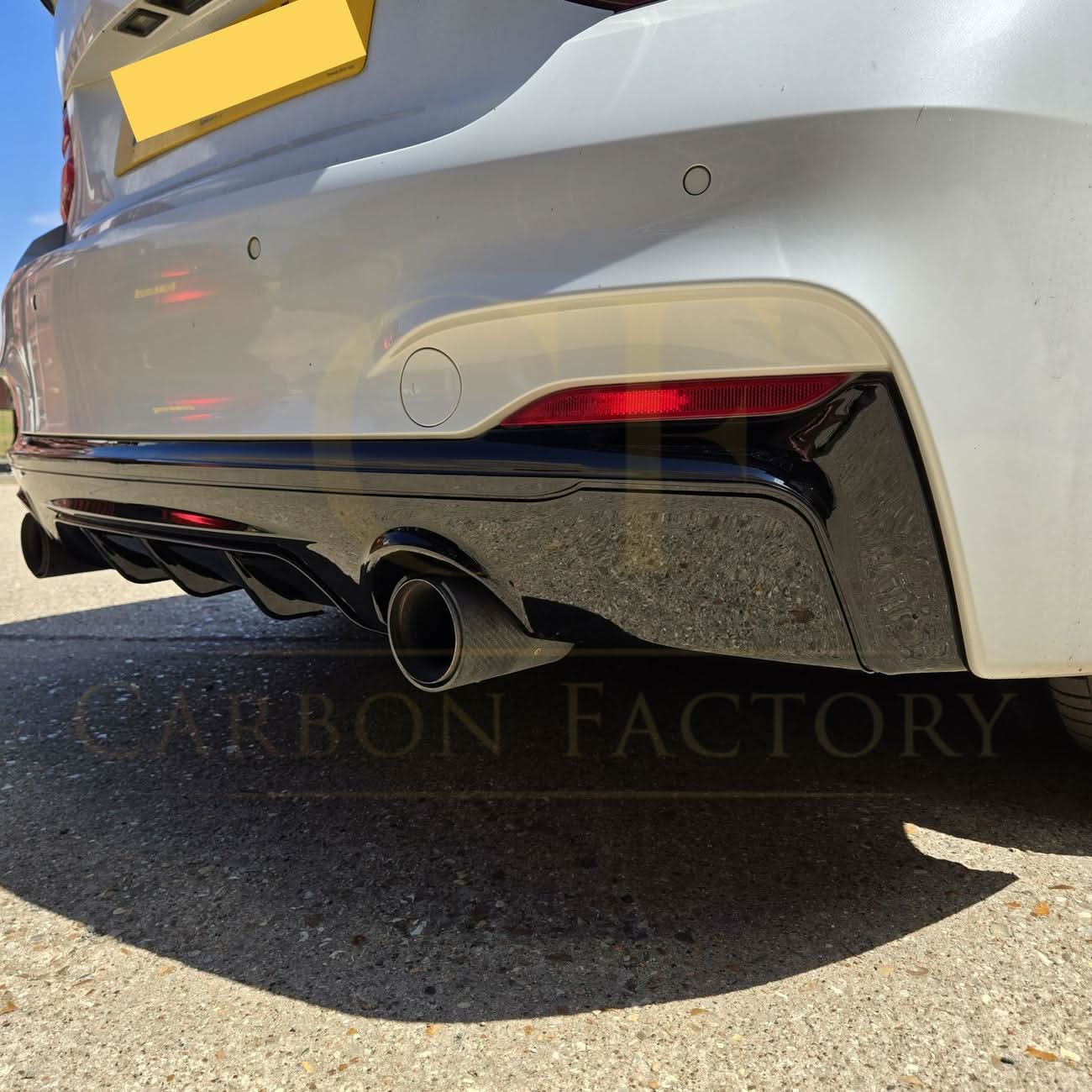 Gloss black rear diffuser with dual exhaust for BMW F22 2 Series M Sport, showcasing sleek design and sporty styling.