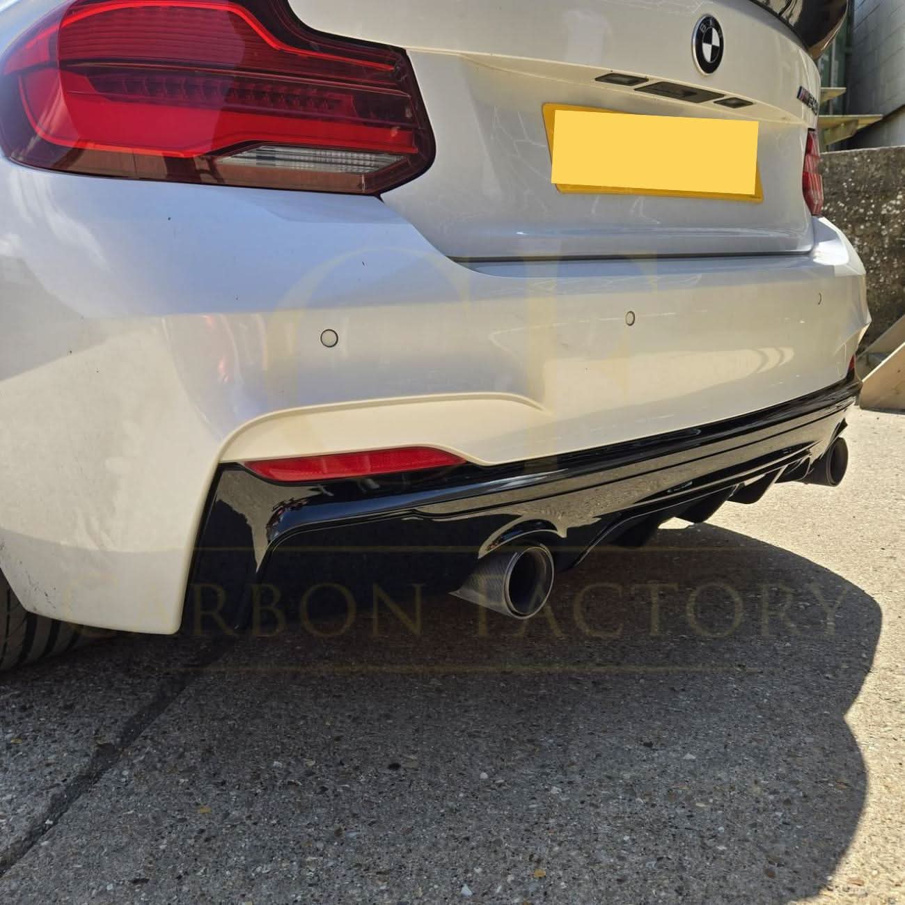 Gloss black rear diffuser with dual exhaust for BMW F22 2 Series M Sport, featuring aerodynamic design and sporty styling.