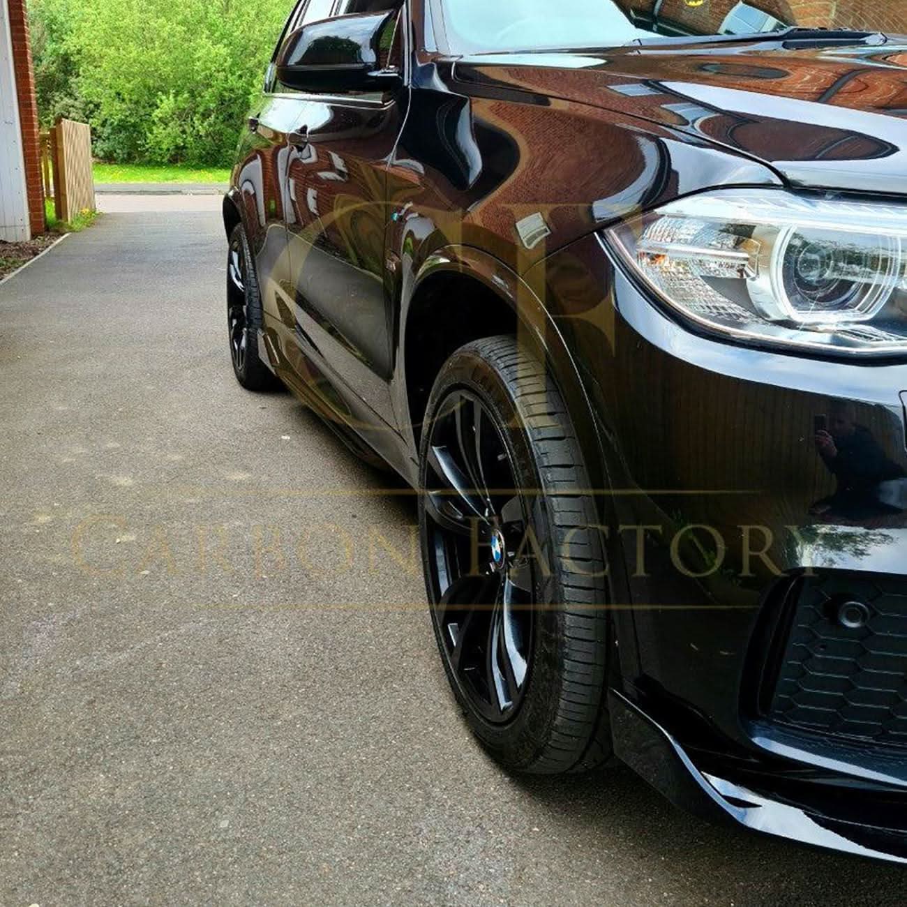 Gloss black BMW F15 X5 body kit with side skirts, splitter, diffuser, and spoiler, featuring carbon factory style design.