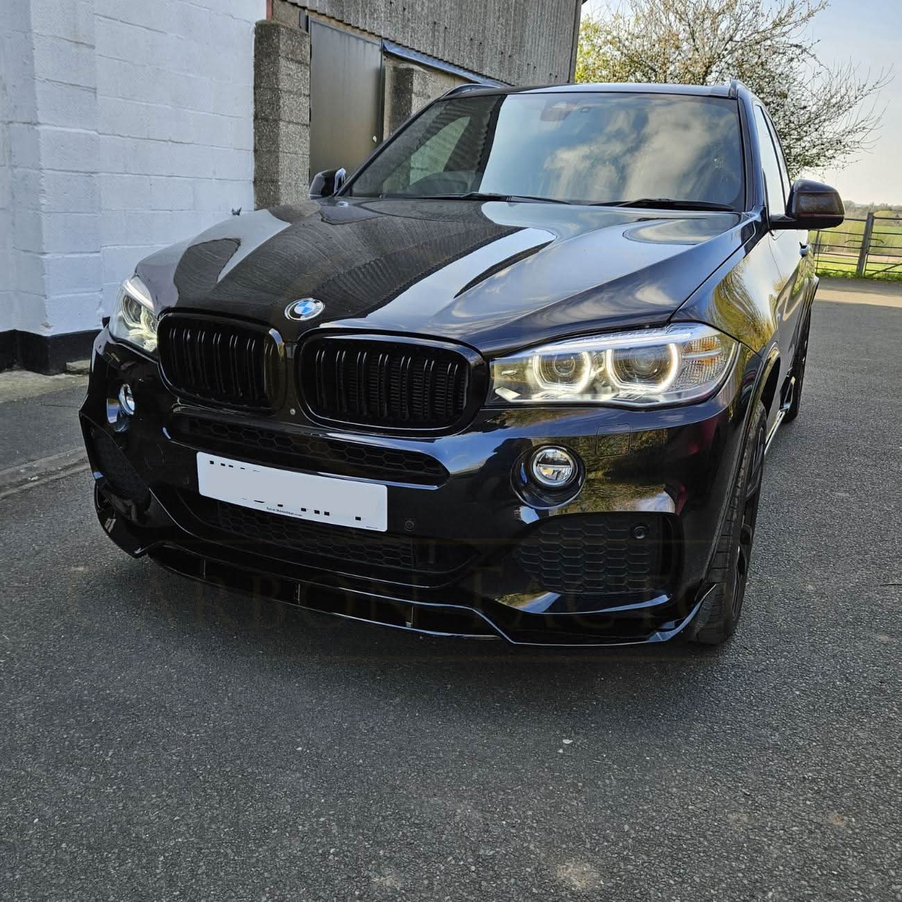 Gloss black carbon fiber body kit for BMW F15 X5, including side skirts, splitter, diffuser, and spoiler.