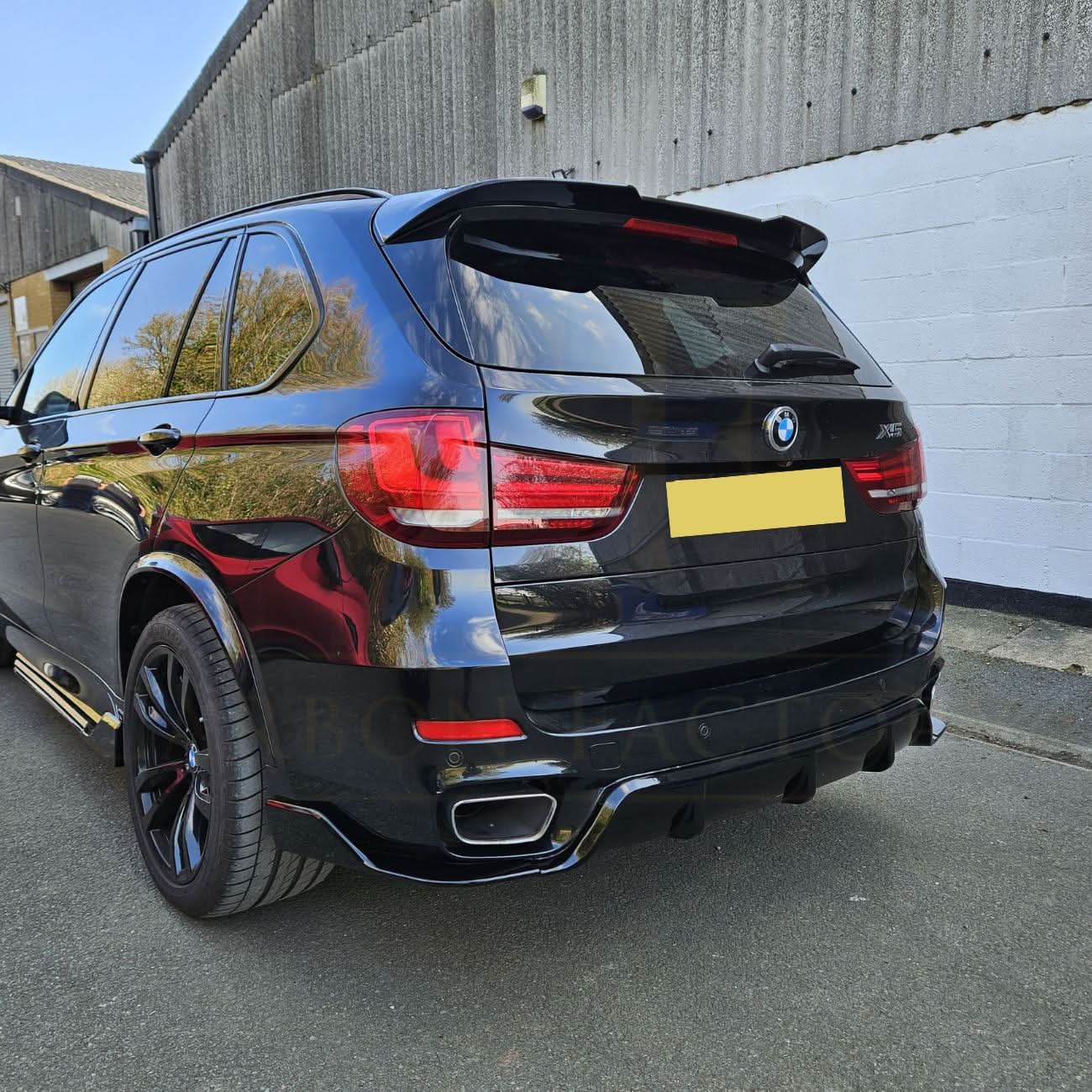 Gloss black BMW F15 X5 body kit with side skirts, splitter, diffuser, and spoiler, featuring a carbon factory style finish.