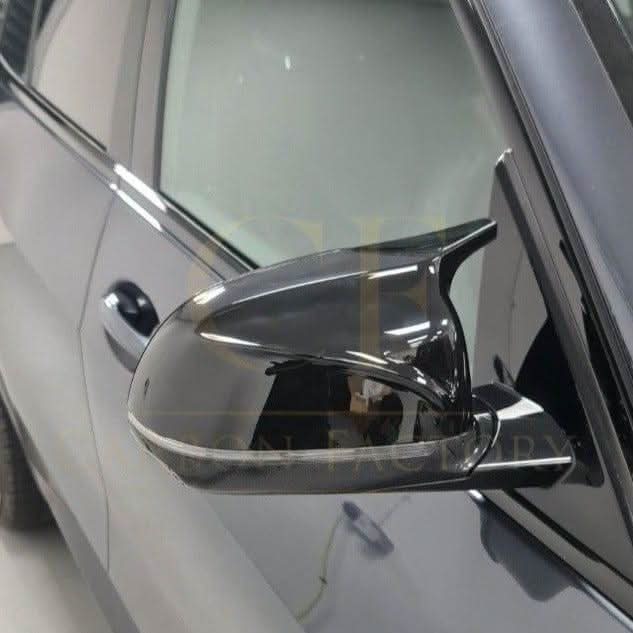 CF Style gloss black replacement mirror covers for BMW G01 X3 G02 X4 G05 X5 G06 X6 G07 X7 2018-2025 models, front view.