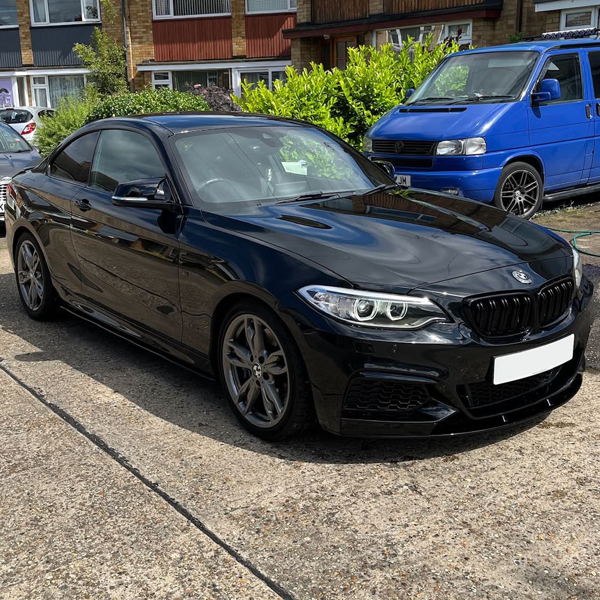 Gloss black side skirt for BMW F22 2 Series and F87 M2, MP Style aftermarket car body kit, visible on vehicle side.