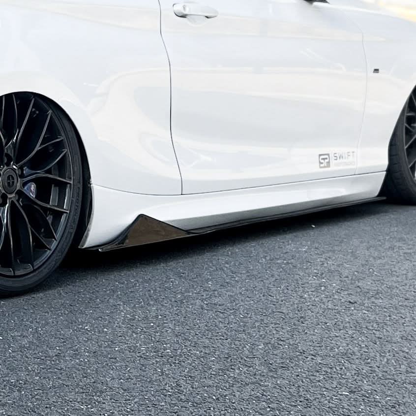 Gloss black side skirts for BMW F22 2 Series and F87 M2, featuring sleek MTC Style design for a sporty look.