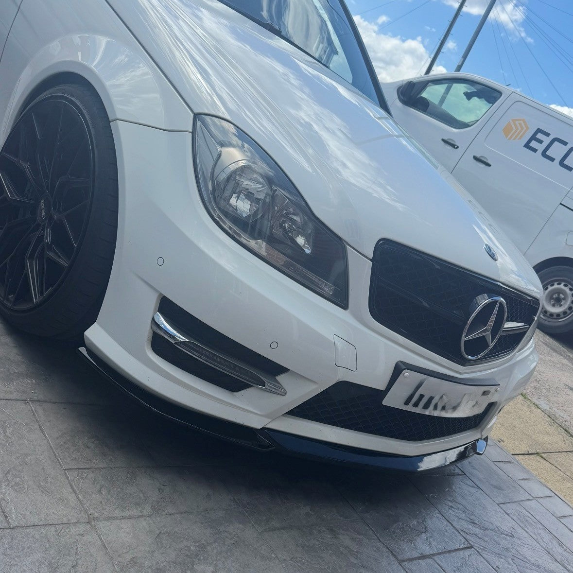 Gloss Black front splitter for Mercedes Benz W204 C-Class 2008-2014, designed to enhance vehicle's sporty look and aerodynamics.