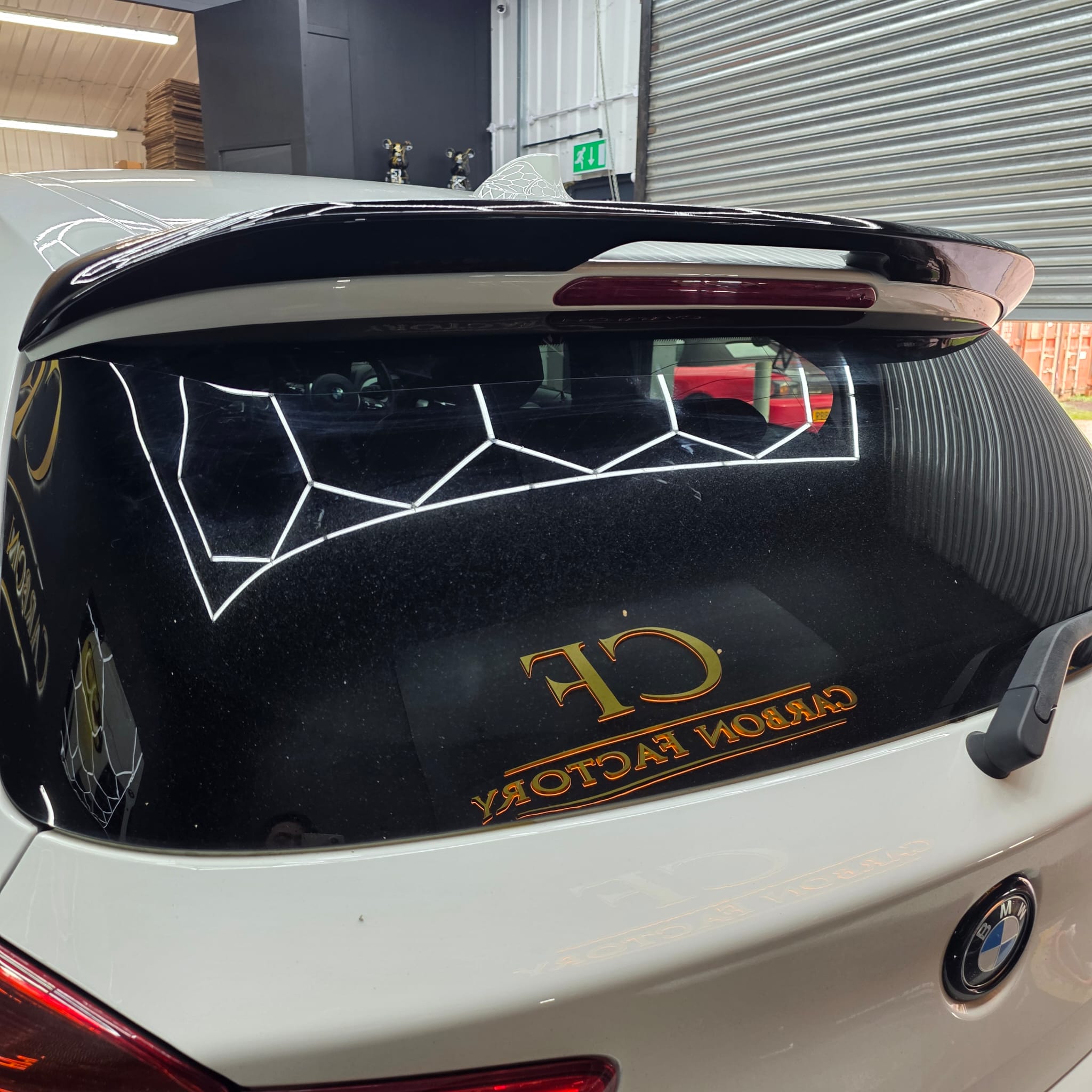 Gloss black roof spoiler for BMW F20 F21 1 Series, sleek aerodynamic design, shown installed on the vehicle.