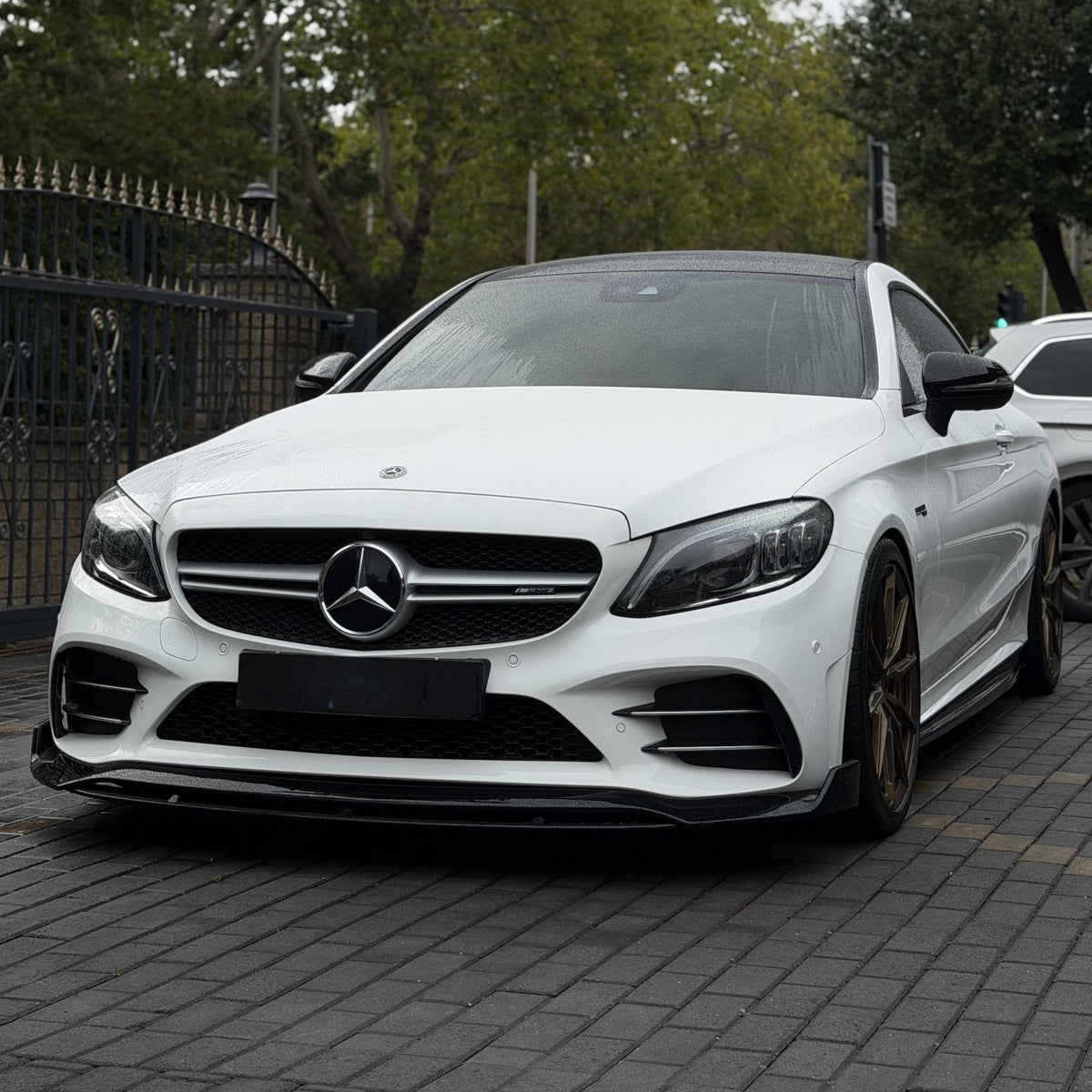 Gloss black front splitter for Mercedes Benz W205 C-Class AMG, styled with a split design, vehicle enhancement accessory.