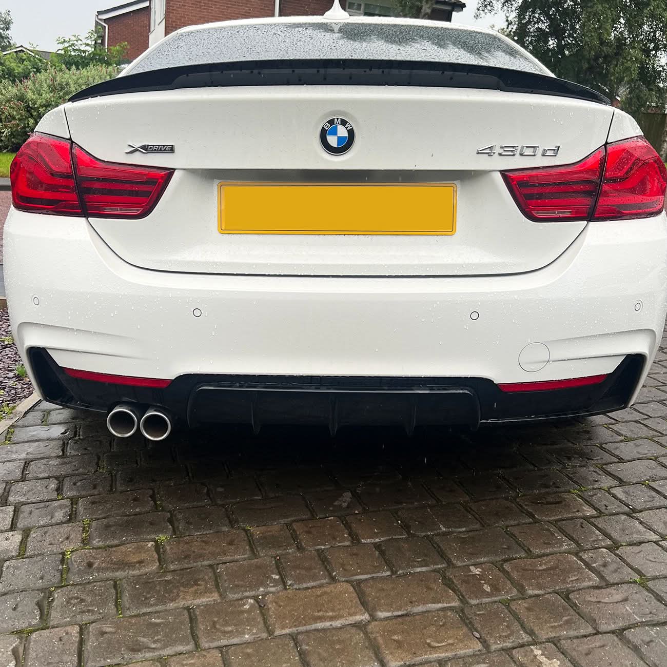 Gloss black rear diffuser with twin exhaust outlets for BMW F32, F33, F36 4 Series models from 2014 to 2020.