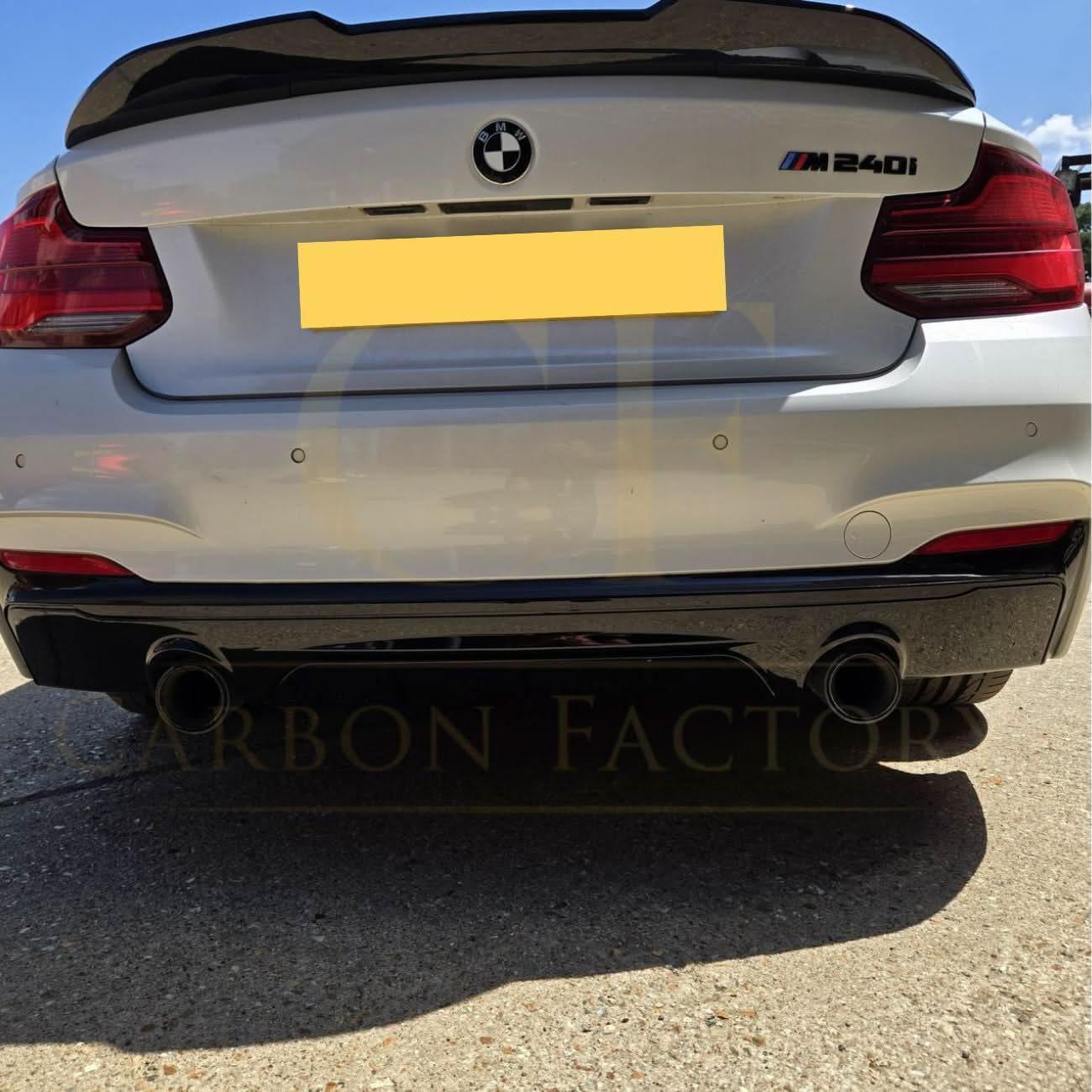 Gloss black rear diffuser with dual exhaust for BMW F22 2 Series M Sport, showcasing sleek design and sporty styling.