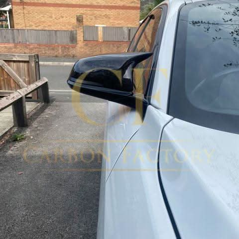 Gloss black M4-style replacement mirror covers for BMW 1, 2, 3, and 4 Series, shown on car mirrors.