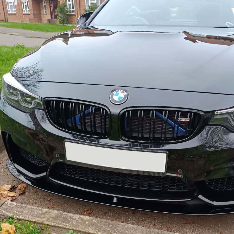 Gloss black MP Style front splitter installed on a BMW F80 M3 and F82/F83 M4 model, enhances sporty front end appearance.
